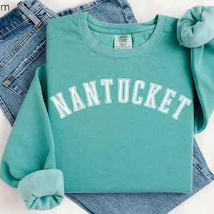 May include: Seafoam green sweatshirt with the word "NANTUCKET" in white text on the front.