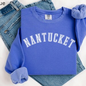 May include: A blue sweatshirt with the word "NANTUCKET" in white lettering across the front.