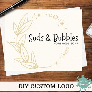 Puede incluir: Un diseño de logotipo para un negocio llamado "Suds & Bubbles" que elabora jabón artesanal. El logotipo presenta una corona de hojas estilizadas con un círculo de estrellas y burbujas en el centro.
