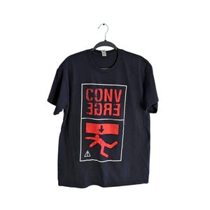 Könnte beinhalten: Schwarzes T-Shirt mit einer roten Grafik des Wortes "CONVERGE" in einem Kasten mit einer roten Strichmännchenfigur, die herunterfällt, und einem roten Pfeil, der nach unten zeigt. Die Strichmännchenfigur trägt einen roten Helm.