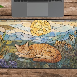 Puede incluir: Una alfombrilla de ratón de estilo vitral con un gato atigrado naranja durmiendo en un campo de flores y un sol en el fondo.