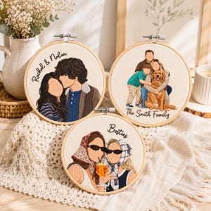 May include: Three circular embroidery hoops featuring custom thread portraits on off-white fabric. One shows a couple with the text Rachel & Nolan, another a family with a dog labeled The Smith Family, and the third two people labeled Besties.