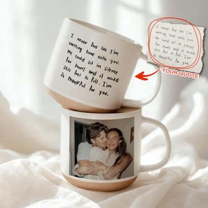 May include: Two white ceramic mugs. The top mug has a quote written in black script: "I never feel like I'm wasting time with you." The bottom mug displays a photo of a couple. Both mugs have a tan base.