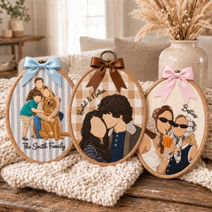 May include: Three oval embroidery hoops featuring custom thread portraits. The left hoop shows a family with a dog on blue stripes with text The Smith Family. The center hoop shows a couple on beige plaid with text Rachel & Nolan. The right hoop shows two people with drinks on cream fabric with text Besties.