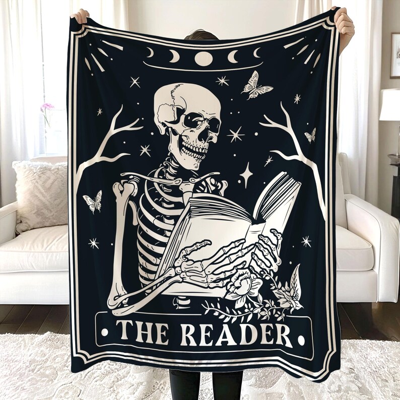 Puede incluir: Tapiz en blanco y negro con un esqueleto leyendo un libro. El tapiz tiene un tema celestial con estrellas, lunas y una mariposa. El texto "THE READER" est&aacute; impreso en la parte inferior.