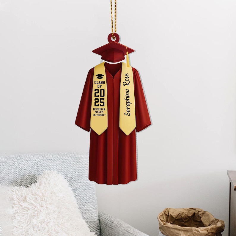 May include: Red graduation cap and gown ornament with a gold tassel and a gold sash with the text "Seraphina Rose" and "Class of 2025 Michigan State University".
