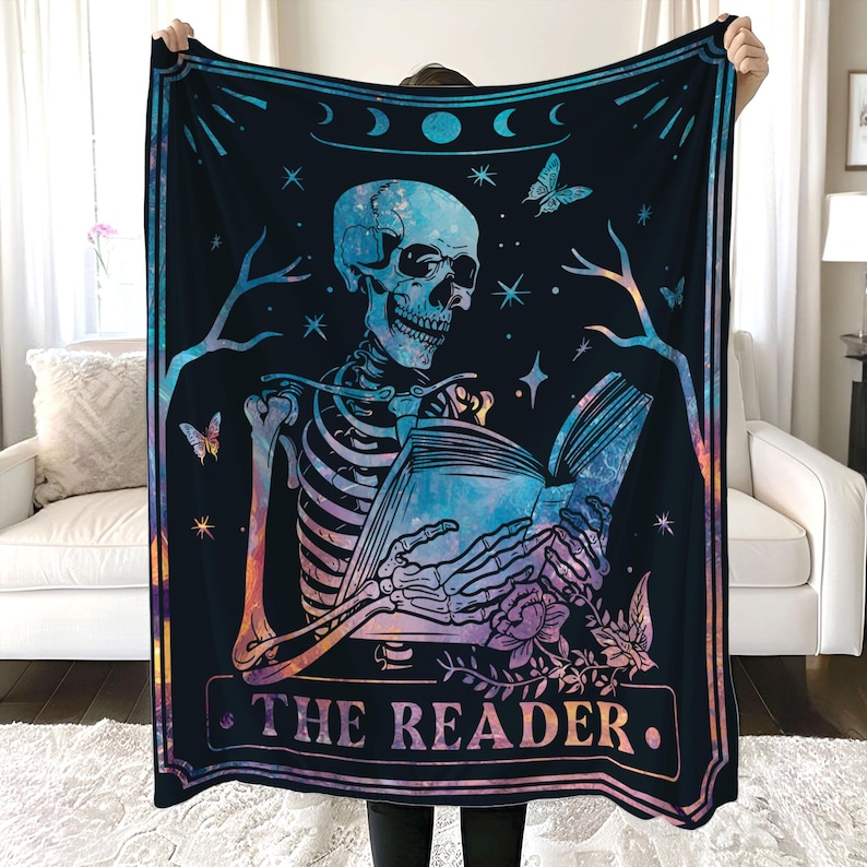 Puede incluir: Un tapiz con un esqueleto sosteniendo un libro, con el texto "THE READER" en la parte inferior. El fondo es azul oscuro con estrellas y un patr&oacute;n de galaxia.