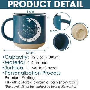 K&ouml;nnte beinhalten: Eine tealblaue Keramiktasse mit einem wei&szlig;en Halbmond- und Bergdesign. Die Tasse hat ein Fassungsverm&ouml;gen von 380 ml und ist 9 cm hoch und 12 cm breit.