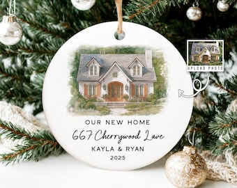May include: A white ceramic Christmas ornament with a watercolor image of a house. The ornament has the text "OUR NEW HOME", the address "667 Cherrywood Lane", the names "Kayla & Ryan", and the year "2025". The ornament hangs from a jute string.