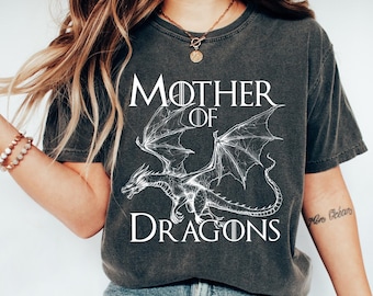 May include: A dark gray t-shirt with a white graphic of a dragon and the text "Mother of Dragons".