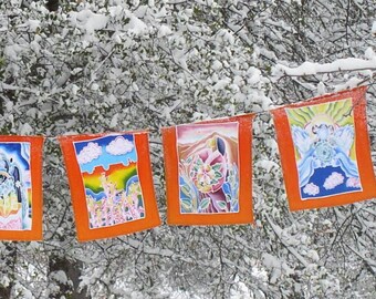 May include: A string of colorful prayer flags hangs from a snow-covered tree branch. The flags are orange with blue, white, and yellow designs. The flags are in a snowy forest setting.
