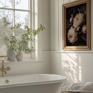 May include: A bathroom scene featuring a white clawfoot bathtub, a framed floral painting, and a wooden stool with a folded white towel. The room has a window with a view and vases with greenery.