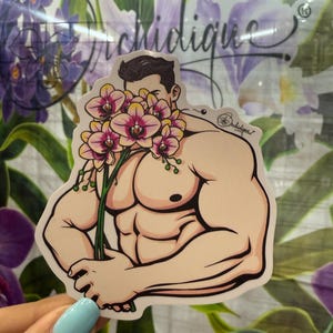 May include: A sticker featuring a muscular figure holding a bouquet of pink and yellow orchids. The figure's face is partially obscured by the flowers. The sticker has a white border and the word "orchidique" is visible.