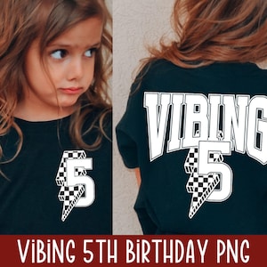 Pode incluir: Uma camiseta preta com texto branco que diz "VIBING 5" com um gráfico de raio xadrez. A camiseta está sendo usada por uma criança.