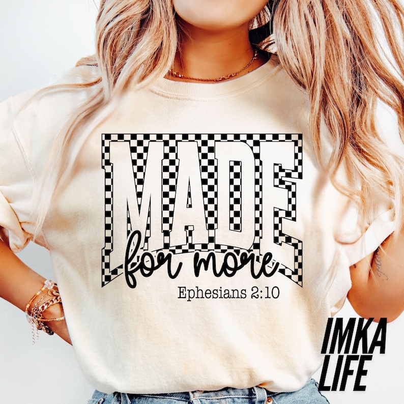 May include: Cream-colored t-shirt with the text "MADE for more" in a black and white checkered design. The text "Ephesians 2:10" is below the main text. The brand name "IMKA LIFE" is in the bottom right corner.