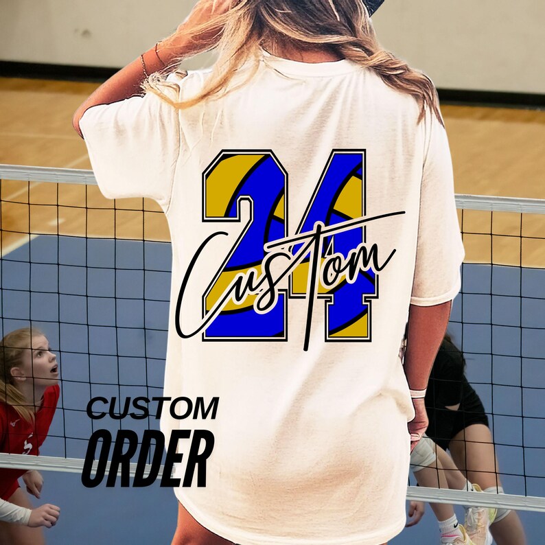 May include: White t-shirt with a custom design featuring the number 24 in blue and gold, with the word "Custom" in a script font. The words "Custom Order" are printed below the design.