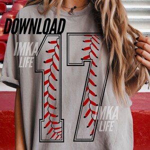May include: A gray t-shirt with the number 17 in a baseball stitch design. The number is outlined in black with red stitching. The words "DOWNLOAD" and "IMKA LIFE" are printed on the shirt.
