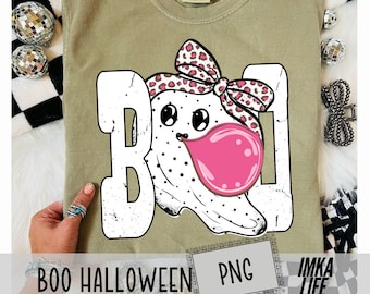 May include: A light green t-shirt with a white "BOO" graphic featuring a ghost blowing a pink bubblegum bubble. The ghost has black polka dots and a bow with a leopard print. The text "BOO HALLOWEEN PNG" is at the bottom.