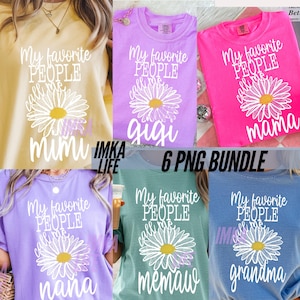 May include: A collection of six colorful t-shirts, each featuring a daisy graphic and the phrase "My favorite people call me" followed by a different name: Mimi, Gigi, Mama, Nana, Memaw, and Grandma. The shirts are in various colors.