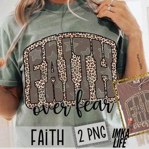 May include: Sage green t-shirt with a graphic that says "FAITH over fear" in a brown, leopard print design. The word "FAITH" is in a block letter style with star accents. The words "over fear" are in a cursive font.