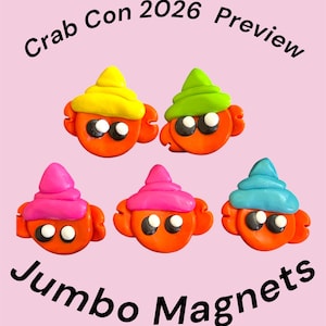 Op de afbeelding: Vijf oranje krabmagneten met grote zwart-witte ogen, elk met een andersgekleurde schelphoed in geel, limoengroen, felroze, magenta of lichtblauw. De tekst Crab Con 2026 Preview en Jumbo Magnets is in het zwart afgedrukt.