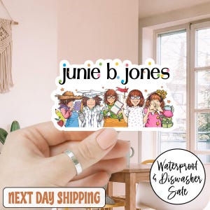 May include: A colorful sticker featuring the text "junie b. jones" above an illustration of five girls. The girls are depicted with books, hats, and glasses. The sticker also includes the text "Waterproof & Dishwasher Sale."