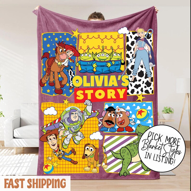 Puede incluir: Una manta rectangular morada con personajes de la pel&iacute;cula "Toy Story". La manta presenta el texto "Olivia's Story" e im&aacute;genes de Woody, Buzz Lightyear y otros personajes. La manta est&aacute; hecha de un material suave y afelpado.