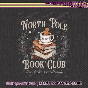 Może przedstawiać: Świąteczny projekt graficzny ze stosu książek, filiżanki gorącej czekolady i piernikowego ludzika. Słowa "North Pole Book Club" są wyświetlane ozdobną czcionką, z tekstem "Hot Cocoa Served Daily" poniżej.