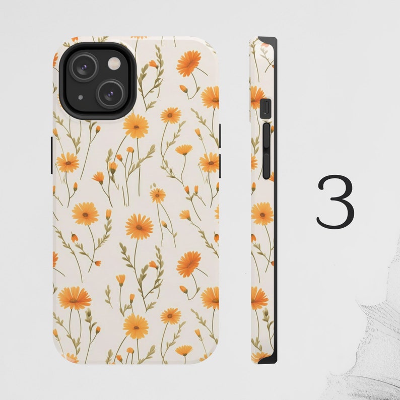 May include: A white phone case with a pattern of yellow flowers. The case has a black camera cutout and a black side.