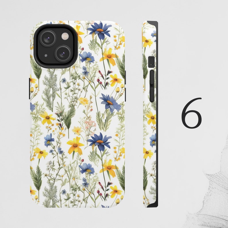May include: A white phone case with a floral pattern featuring blue and yellow flowers. The case has a black camera cutout and a black border.