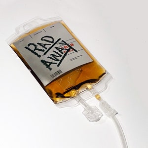 May include: A clear plastic bag containing a yellow liquid. The bag has a label that reads "RAD AWAY" with a date of "5/8/2022". Two clear plastic tubes are attached to the bag.