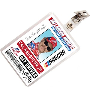 Peut inclure: Une carte d'identité en plastique blanc avec une photo d'un homme portant une casquette de course rouge, blanche et bleue et des lunettes de soleil. La carte porte le texte "Talladega Nights: The Ballad of Ricky Bobby" et "NASCAR" en rouge et blanc. La carte porte également le texte "Cal Naughton Jr. #47 Driver" et un code-barres.
