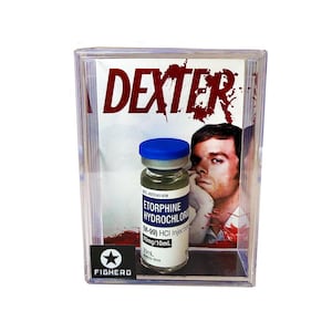 Könnte beinhalten: Eine transparente Acryl-Vitrine mit einem Fläschchen mit blauem Verschluss und der Aufschrift "ETORPHINE HYDROCHLORIDE". Der Hintergrund zeigt das Wort "DEXTER" in Rot und ein Männerporträt. Das Fläschchen ist mit "M-99) HCI Injection 10mg/10mL" beschriftet.