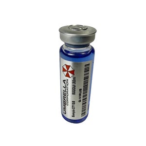 Peut inclure: Un petit flacon en verre avec un bouchon argenté, rempli de liquide bleu. Le flacon porte une étiquette avec le texte "UMBRELLA CORPORATION" et un logo rouge et blanc. L'étiquette comprend également "G-VIRUS" et "5000UI 30ml".