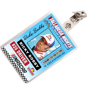 May include: A blue and white plastic ID card with a photo of a race car driver. The card has the text "Talladega Nights: The Ballad of Ricky Bobby" and "Ricky Bobby" in black text. The card also has the text "#26 Driver NASCAR" and "Wonder" in red, white, and blue text. The card has a barcode and the text "ID: 5329-019470050-000".