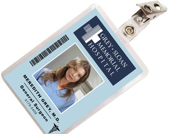 May include: A blue and white plastic ID badge with a photo of a woman and the text "GREY+SLOAN MEMORIAL HOSPITAL" and "MEREDITH GREY M.D. General Surgeon 0178-5409".