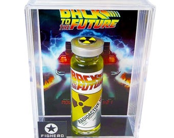May include: A clear display case featuring a "Back to the Future" themed radioactive plutonium vial. The vial has a yellow liquid and a radioactive symbol. The background shows the movie's logo and a DeLorean.