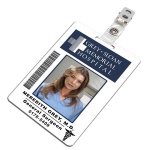 Può includere: Tessera di riconoscimento in plastica bianca con un logo blu e bianco per l'ospedale Grey Sloan Memorial. La tessera ha una foto di una donna con i capelli castani e una divisa blu. Il testo sulla tessera recita "Meredith Grey, M.D. Chirurgo Generale 0178-5409".