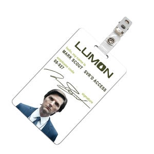 May include: A white plastic ID card with the text "LUMON SVR'D ACCESS" in green. The card has a photo of a man in a suit and the text "hello, my name is MARK SCOUT" and "employee code 08-927".
