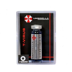 Könnte beinhalten: Ein Fläschchen mit blauer Flüssigkeit, das mit "T-VIRUS" beschriftet ist, in einem transparenten Kunststoffgehäuse. Das Fläschchen hat einen silbernen Verschluss und ein Etikett mit dem Logo "Umbrella Corporation". Das Gehäuse trägt ebenfalls das Logo "Umbrella Corporation" und das Wort "FIGHERO".