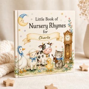 May include: A children's book titled "Little Book of Nursery Rhymes for Charlie." The cover features illustrations of a moon, goose, sheep, cow, duck, and cat. The book has a cream-coloured background with floral and star accents.