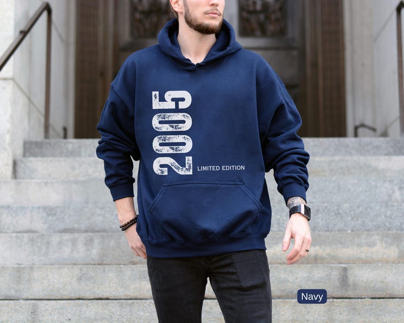 Pu&ograve; includere: Felpa con cappuccio blu navy con l'anno "2005" stampato verticalmente in bianco, insieme alle parole "LIMITED EDITION". La felpa ha una tasca frontale e un cappuccio. Il colore &egrave; indicato come "Navy".