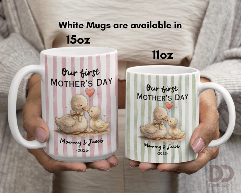 May include: Two white ceramic mugs, 15oz and 11oz, with handles. Each mug features a duck and duckling illustration with the text "Our first MOTHER'S DAY", "Mommy & Jacob -2026-". The larger mug has pink stripes, the smaller has green.