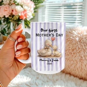 May include: White ceramic mug with a vertical striped pattern in lavender and white. The mug features the text "Our first MOTHER'S DAY" and a watercolor illustration of two ducks. Below the illustration is the text "Mommy & Jacob -2026."