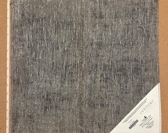 Op de afbeelding: Een vierkant stofstaal met een donkergrijs en zilverkleurig metallic textuurpatroon. Een wit hoeklabel vermeldt CENTURY, Grade A, Pattern 715264.82 Grey, 85% Polyester, 15% Rayon. Een wit meetlint toont een breedte van 43 cm.