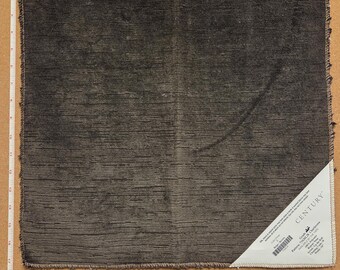 Op de afbeelding: Een vierkant, antracietkleurig stofstaal met een textuur van horizontale lijnen en gerafelde randen. Een wit driehoekig label in de hoek vermeldt CENTURY en productdetails. Een meetlint geeft een breedte van 43,18 cm aan.
