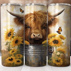 May include: A brown and white Highland cow with long, shaggy hair peeks out of a metal bucket. The cow is surrounded by yellow sunflowers and orange butterflies.