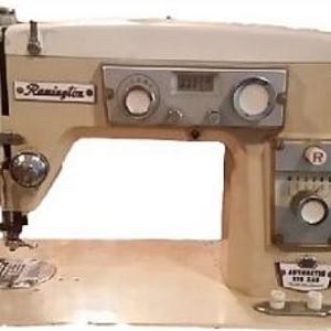 Puede incluir: Una máquina de coser Remington vintage blanca con un panel de control negro y plateado. La máquina tiene un pedal y una aguja.