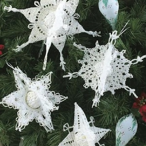 May include: White crocheted snowflake ornaments hanging on a green Christmas tree. The snowflakes are delicate and intricate, with a lacy design.
