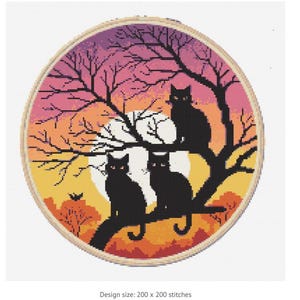May include: A cross-stitch embroidery hoop featuring three black cats perched on a tree branch against a sunset backdrop. The design includes a full moon and bare tree branches, with the text "Design size: 200 x 200 stitches".